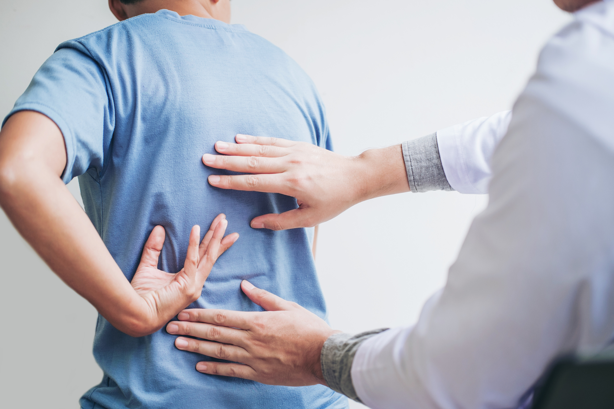 doctor inspecting patient's backpain